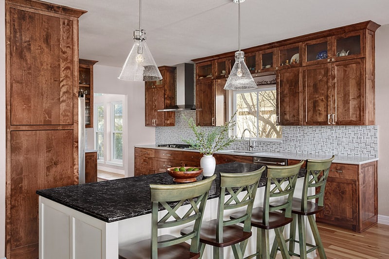 Remodeled kitchen with dark wood cabinets and mosaic tile backsplash